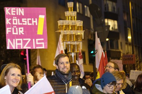 Menschen auf einer Demo gegen rechts halten ein Schild "Kein Kölsch für Nazis" hoch