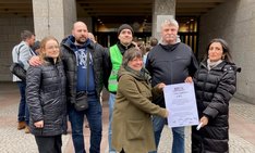 2 Aktivistinnen von Fridays für Future und 2 KVB-Mitarbeiter stehen gemeinsam mit Uschi Röhrig und Güldane Tokyürek vor dem Rathaus und halten ein Protestplakat