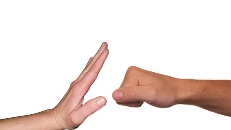 Eine Hand stoppt eine Faust