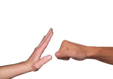 Eine Hand stoppt eine Faust
