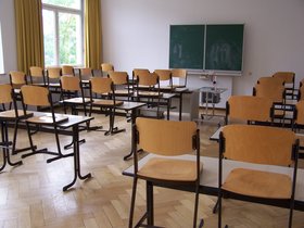 Foto zeigt ein Klassenzimmer mit Tafel